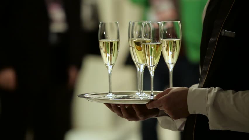 
Glasses of champagne on a tray in the hands of the waiter. | Shutterstock HD Video #1022809435
