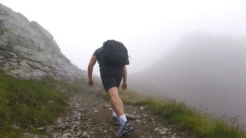 Trail runner with backpack on a steep mountain course