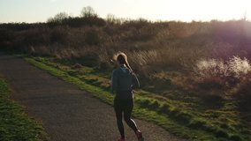 Aerial Shot, Tracking Shot of running jogging sporty girl woman