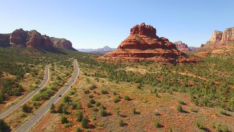 aerial drone footage of sedona arizona red rock mountains and highway