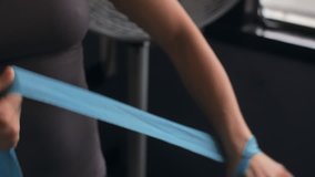 Close up of a female boxer tying hand wraps around her wrists before a workout - Powered by Shutterstock - Get 15% off with code: PIKWIZARD15