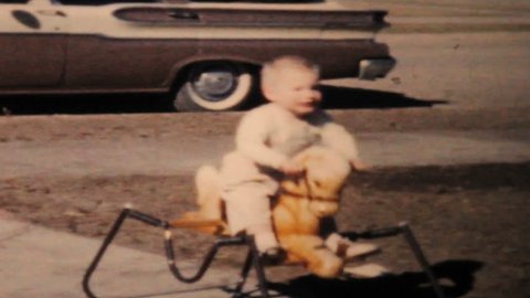 WALLA WALLA, WASHINGTON, 1964: A cute little boy going crazy on his new rocking horse outside his home in the summer of 1964.