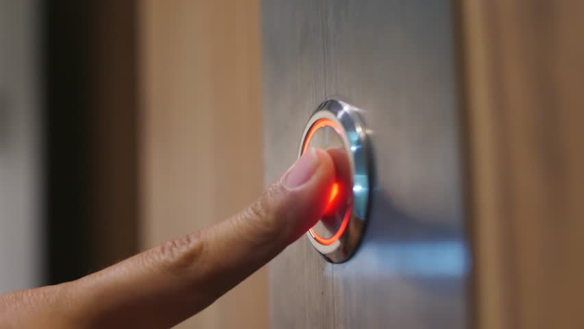 Female Hand Pushing Elevator Button in Office Center or Hotel. Young Woman Pressing Lift Button Down. 4K Slowmotion.