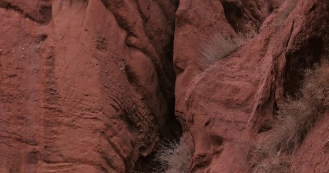 Handheld tilt up shot, of details on the red sandstone mountains, on a cloudy day, at Jeti-Oguz, in Kyrgyzstan