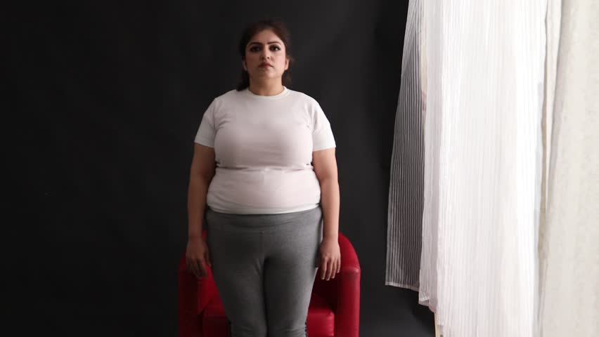 Fat young woman checking her size, disappointed to see her over weight
 Royalty-Free Stock Footage #1022855872