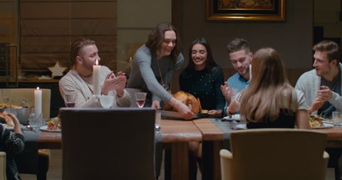 Sisters or friends holding tray with huge turkey for thanksgiving dinner, happy large family cheering. 4K UHD 60 FPS SLOW MOTION Blackmagic RAW