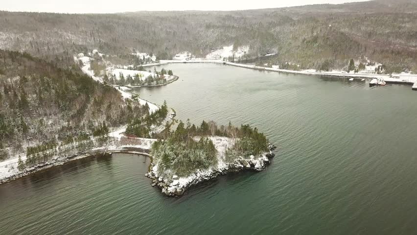 Aerial Shot of snowing forested village with water, Nova Scotia, Canada