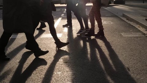 Crowd of anonymous people walking on busy city street in Barcelona pedestrians and tourists sunset silhouette, safe travel post covid
