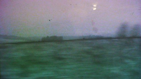 VHS effect over cinematic view through the window of a fast TGV ICE train over the French hills and villages early in the morning on the cold snowy winter - 4K UHD footage