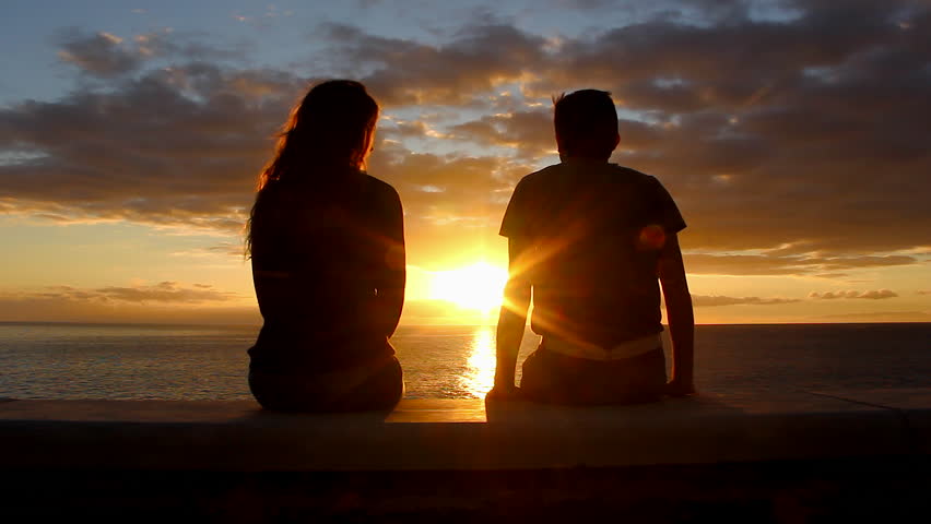 Man and woman sitting by the sea enjoy sunset at Meloneras beach walk, Gran Canaria. Couple silhouette staring at colorful twilight start kissing. Valentines Day, honeymoon romantic date concepts Royalty-Free Stock Footage #1022891878