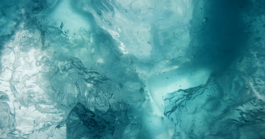 Underwater ice with rising water bubbles. Macro shot of beautiful blue underwater ice. Royalty-Free Stock Footage #1022909947