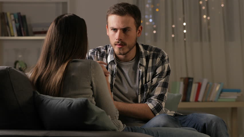 Angry man breaking up with his girlfriend on a couch in the night at home | Shutterstock HD Video #1022911519