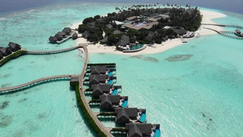 Aerial view of  luxury 5 star resort hotel water bungalow on Maldives white sandy beach 
