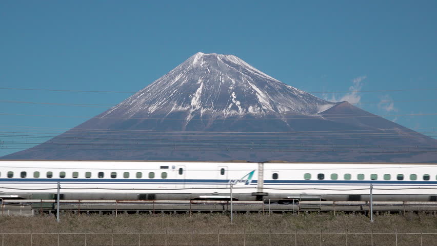 A Shinkansen bullet train passes below Mt. Fuji in Shizuzoka, Japan

 Royalty-Free Stock Footage #1022913916