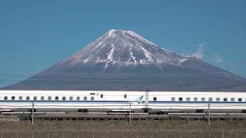 A Shinkansen bullet train passes below Mt. Fuji in Shizuzoka, Japan

