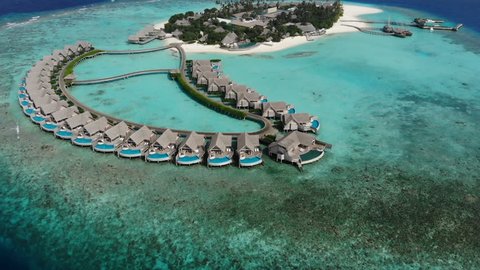 Aerial view of  luxury 5 star resort hotel water bungalow on Maldives white sandy beach 
