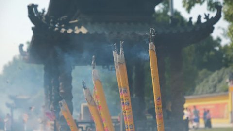 Incense sticks are burning slowly in the burner of a chinese temple. Close focus of incense with copy space for text or advertising.