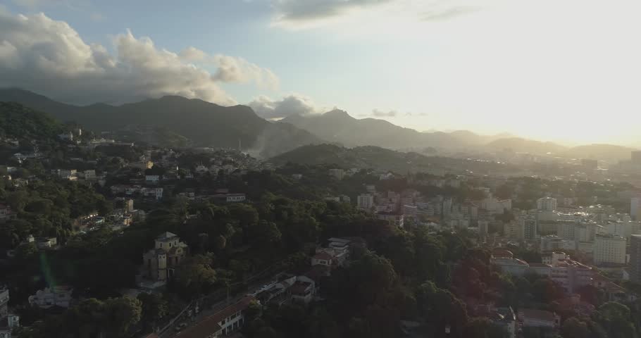 Sunset aerial pan over central downtown Rio de Janeiro Brazil from leafy hilltop neighbourhood of Santa Teresa