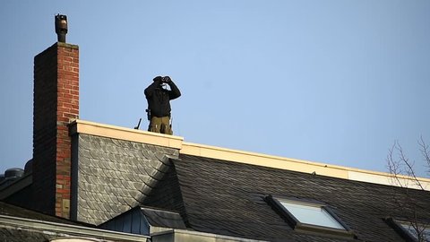 Special forces sniper securing a perimeter from a rooftop 