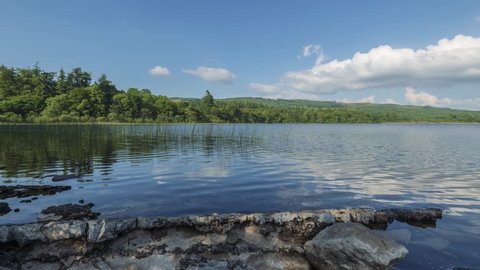 Time Lapse of Lake Shore with Rocks reflected on Summer Day in Ireland.
