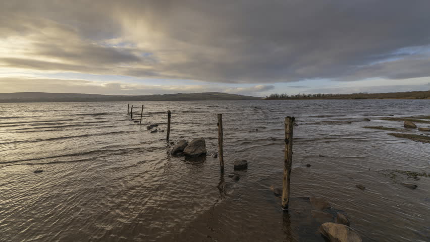 Time Lapse of Lake Shore with Pillars and Rocks on Cloudy Day in Ireland.