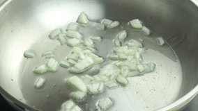 Macro video of frying chopped garlic in vegetable oil
