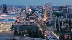Aerial: flying above the city buildings of downtown Sacramento at night, California, USA 