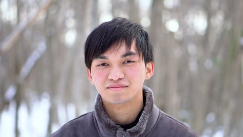 Dolly in Shot - Happy Smiling Young Mixed Ethnicity Asian Man In Snowy Winter Scene