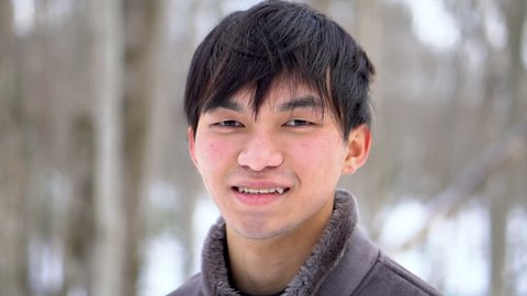 Happy Smiling Young Asian Man In Snowy Winter Scene