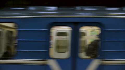 CINEMAGRAPH - Blue subway train with people inside moving fast, view from metro station. Close up for windows of subway train passing fast at underground station