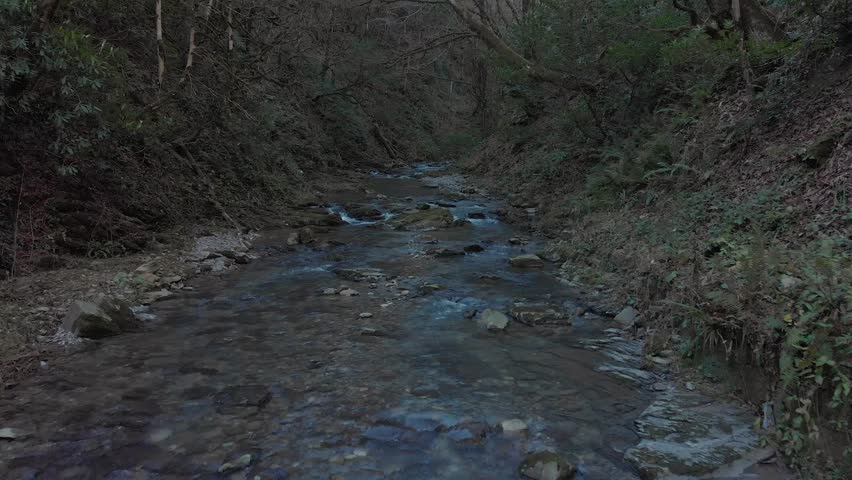 Aerial Drone low flight above blue creek. Look down shot. Smooth and slow forward flight