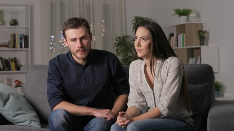 Woman rejecting boy in a first date sitting on a couch in the night at home