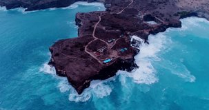Drone footage of the west coast of Nusa Penida, Indonesia with Angel Billabong and boken beach, many small water pools along the coast and big waves crashing into the rocks. The camera is facing down