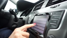 VIDEO slow motion, woman finger browsing on touch screen display inside the car
