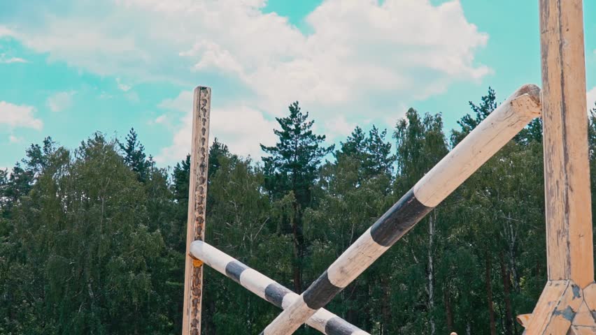 Young woman on horse jumping over obstacles. Slow motion. Training horses before the competition. Horse Racing. Horse breeding. Farm. Horseman. Rider, equestrian, jockey