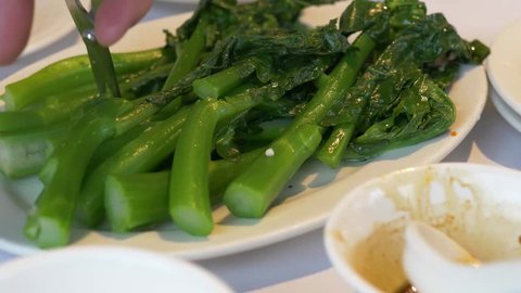 VANCOUVER,CANADA - CIRCA December 2018 :cutting chinese green broccoli in slow motion gai lan
