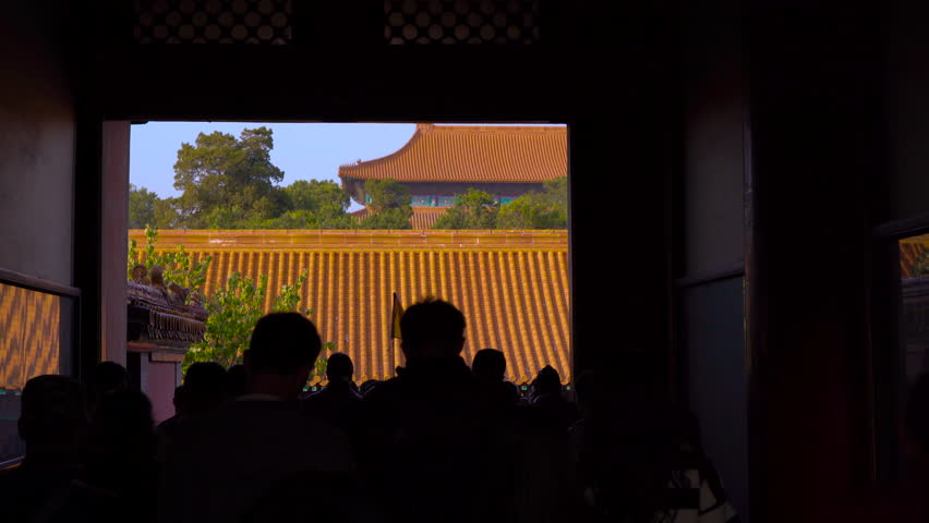 Steadicam shot of a huge crowd of people tourists walking through the entrance tunnel into the Forbidden city in the capital of China