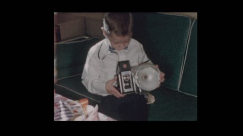 1956 Little boy dressed up in bow tie with vintage antique flash camera