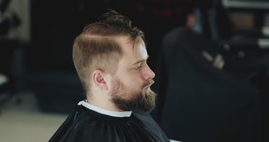 Handsome caucasian man getting a haircut in a modern barber shop. 4K Footage Raw edited. - Video