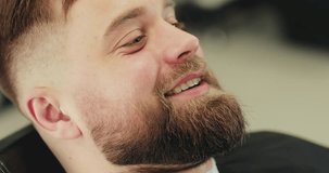 Handsome caucasian man getting a haircut in a modern barber shop. 4K Footage Raw edited. - Video
