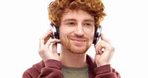 Beautiful happy fun young adult redhead man listening to music using headphones and dancing.Person action.People video portrait isolated on white background.Medium shot.4k video