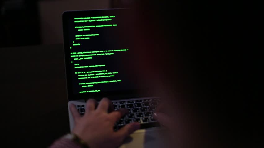 IT Programmer Hacker is Coding Program using Laptop Computer in the Late Night. Man is Working and Typing on a Computer Developing Code with Green Characters in a Dark room. - Powered by Shutterstock - Get 15% off with code: PIKWIZARD15