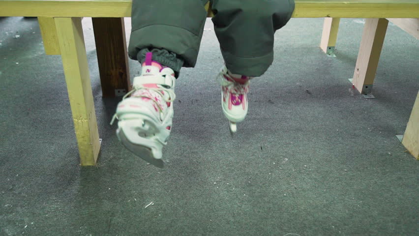 Little Girl Waving her Legs in Skates on a Bench