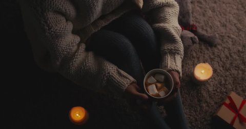 Cup Of Hot Chocolate With Marshmallow And Woman Legs In Cozy stockings in the evening