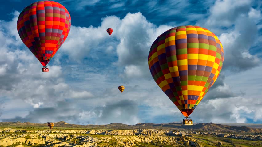 Cinemagraph of hot air balloons rising over the Cappadocia, Turkey desert amidst churning time lapse clouds. Royalty-Free Stock Footage #1023043999