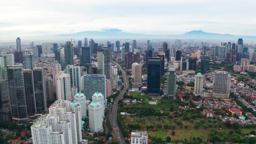 JAKARTA, Indonesia - January 22, 2019: Drone view of modern skyscrapers with highway and mountain view in Jakarta, Indonesia. Shot in 4k resolution | Shutterstock HD Video #1023049441