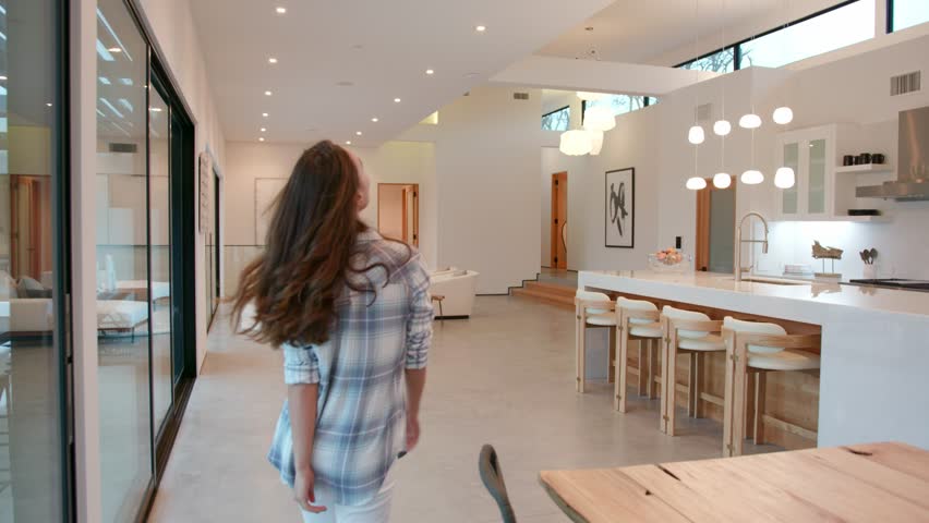 woman walking into a huge modern contemporary home that she rented for a vacation, she is amazed about it  Royalty-Free Stock Footage #1023051235