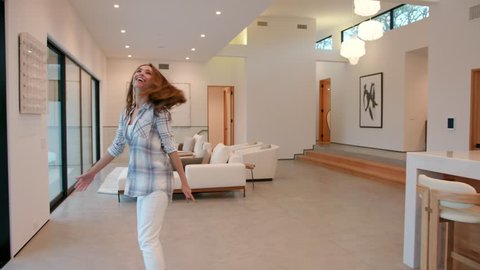 woman walking into a huge modern contemporary home that she rented for a vacation, she is amazed about it 