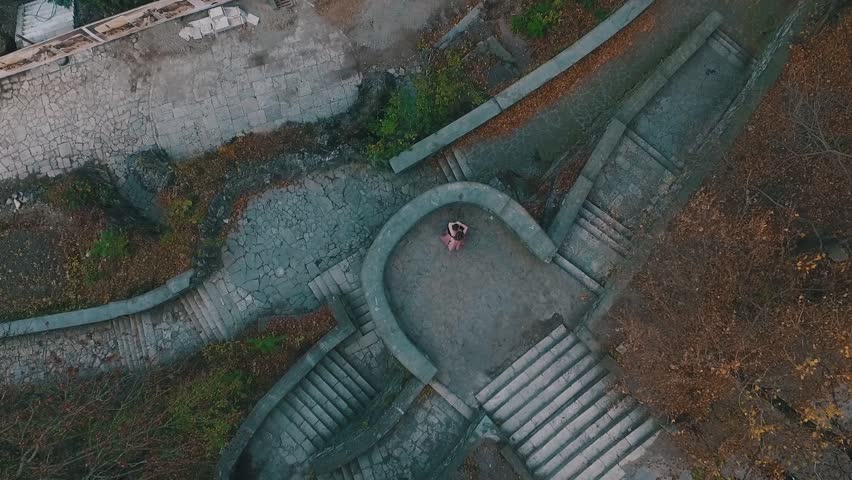 A young Man in an Elegant Black Suit hugged his girlfriend and circling the top view of the quadcopter