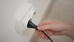 White plug in a wall socket rapid video